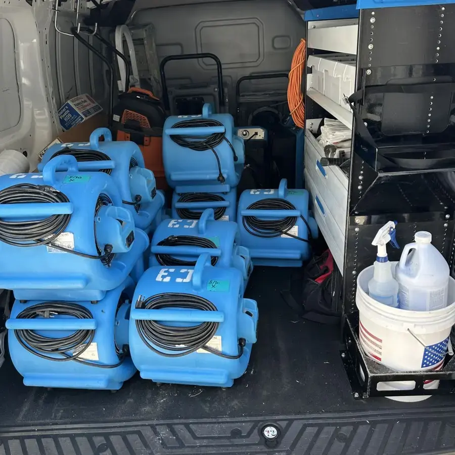 Air movers, a dehumidifier and cleaning supplies loaded in a restoration van