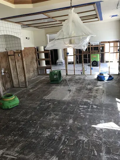 Containment plastic and air movers in a gutted kitchen during a La Puente dry-out