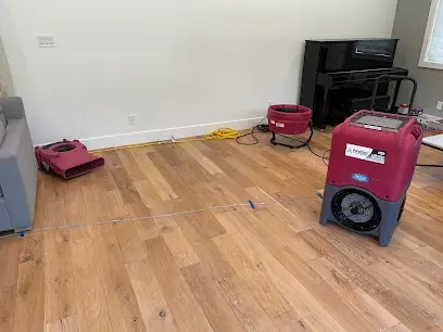 Dehumidifier and air mover drying a hardwood floor