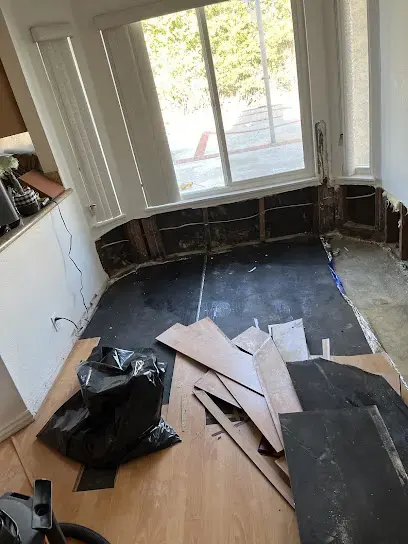 Wet flooring pulled up and bagged so the slab can dry